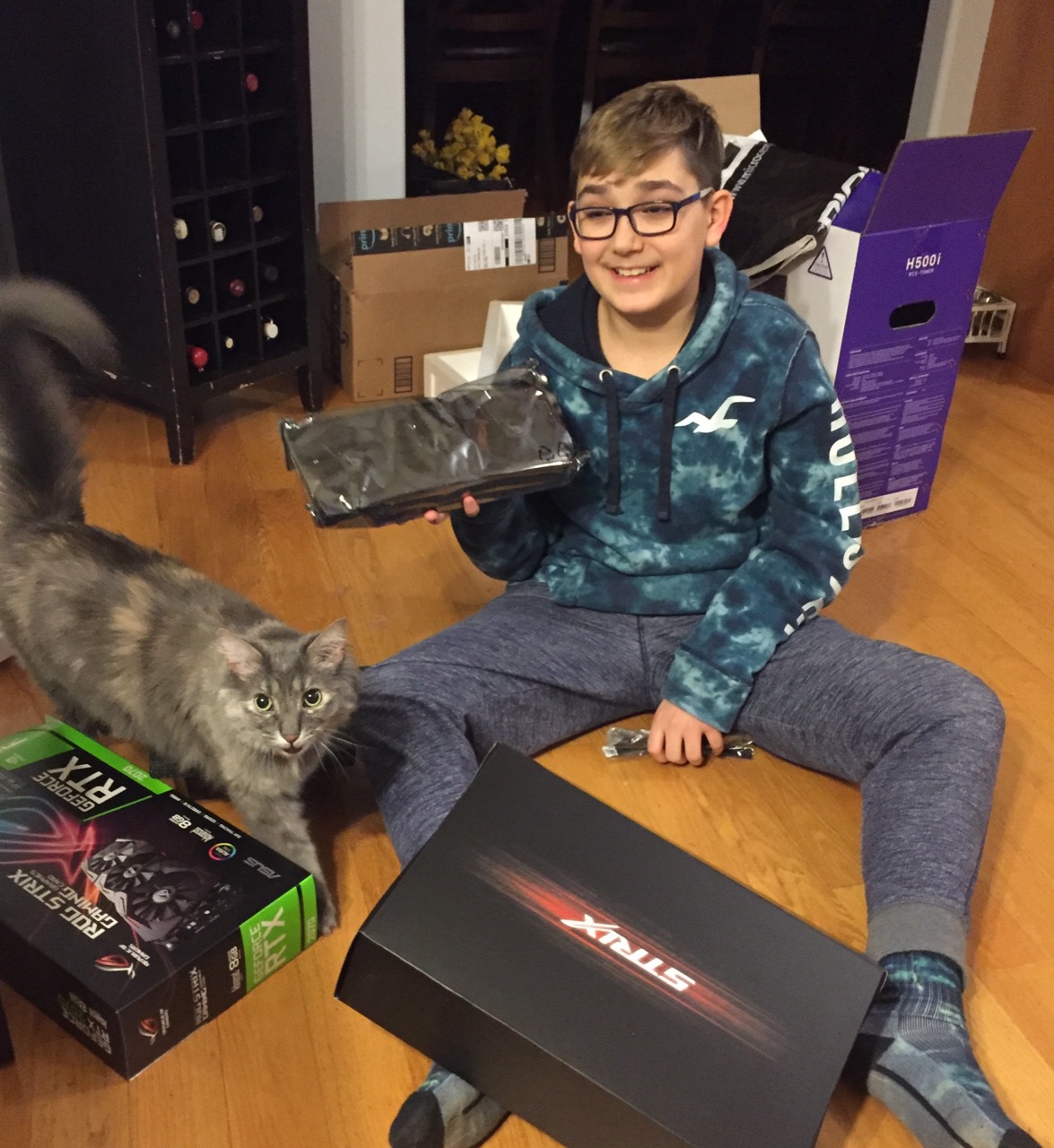 Alex around age 12 holding his first graphics card beside his cat Bella